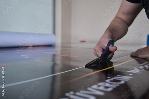 Man cutting print paper with scissors 