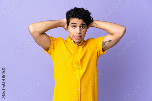 Young Venezuelan man isolated on purple background doing nervous gesture
