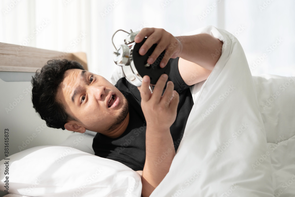 Fototapeta premium A Man Wake Up in the Morning By His Bed Side Alarm Clock