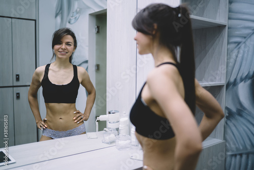 Portrait of smiling caucasian female looking at camera smiling satisfied with perfect body shape, happy pretty woman in underwear enjoying results of slimming and keeping healthy lifestyle