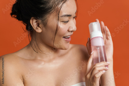 Image of smiling shirtless asian girl posing with cleansing foam