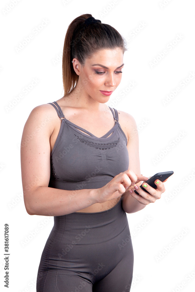 woman athlete in sportswear looks at the phone while holding it in hand woman athlete in sportswear looks at the phone while holding it in hand