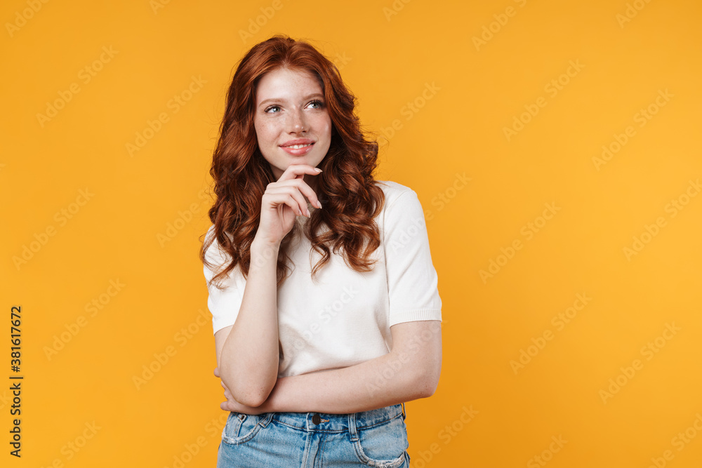 Image of ginger joyful girl smiling and looking aside Image of ginger joyful girl smiling and looking aside