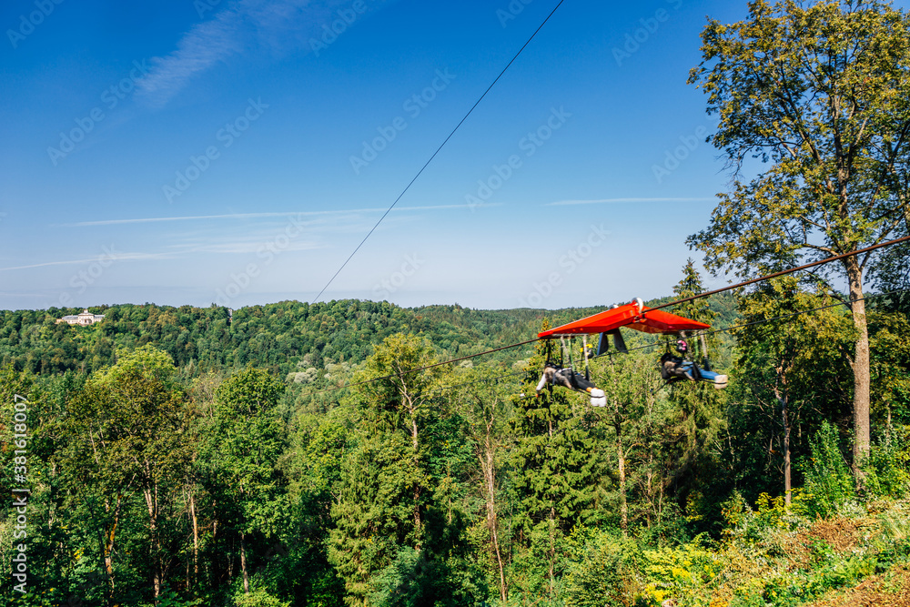 Zipline adventure activity for Cablecar Sigulda to Cablecar Krimulda with green forest mountain in Sigulda, Latvia Zipline adventure activity for Cablecar Sigulda to Cablecar Krimulda with green forest mountain in Sigulda, Latvia