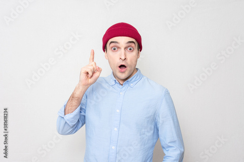 Excited guy having good idea and pointing up, white background, copy space