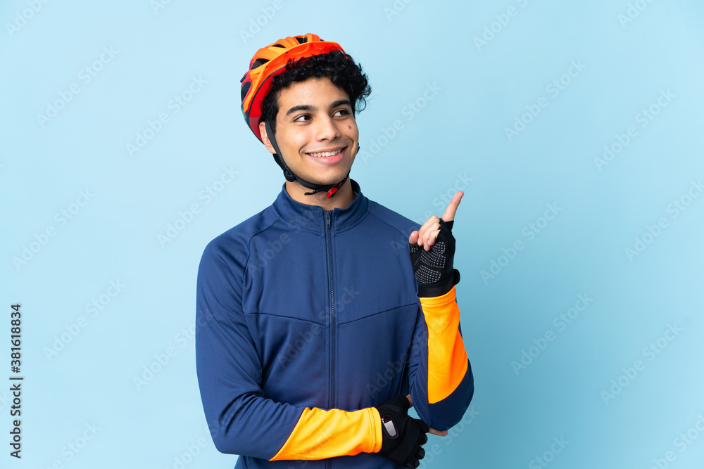 Venezuelan cyclist man isolated on blue background pointing up a great idea Venezuelan cyclist man isolated on blue background pointing up a great idea