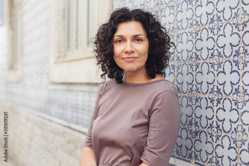 A young pretty woman. Traditional Portuguese building with azulejo tiles on the background.