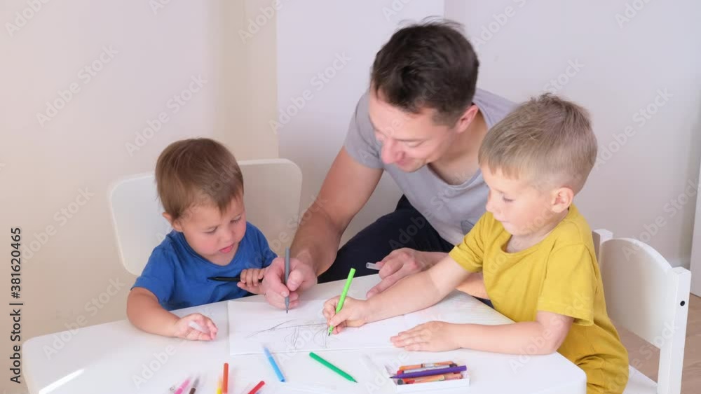 Young father and his two kids drawing together Young father and his two kids drawing together
