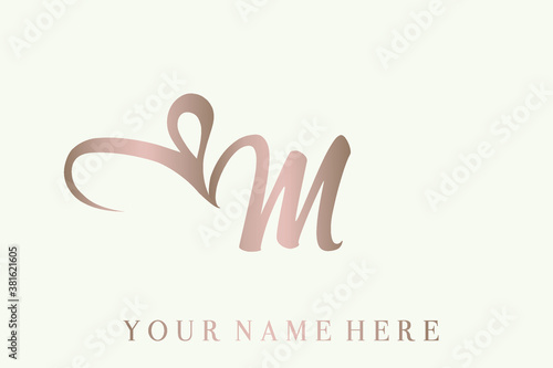 Letter m logo with ribbon heart shape.Romantic, feminine style.Calligraphic lettering icon in rose gold color isolated on light background.Script lowercase alphabet initial shape with love sign.