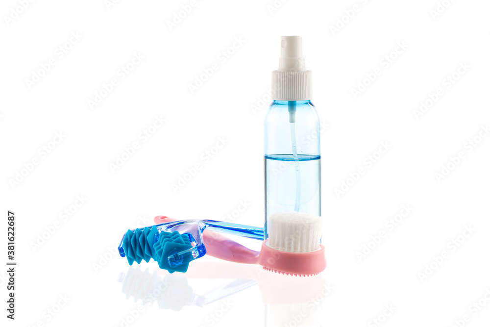 Skin care set isolated on white background. Transparent bottle with liquid facial moisturizing spray and cleansing brush, derma roller kit for face massage, skincare tools for daily deep cleansing Skin care set isolated on white background. Transparent bottle with liquid facial moisturizing spray and cleansing brush, derma roller kit for face massage, skincare tools for daily deep cleansing