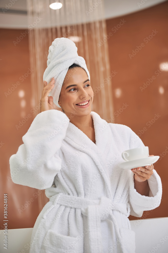 Cheerful young woman holding cup of coffee