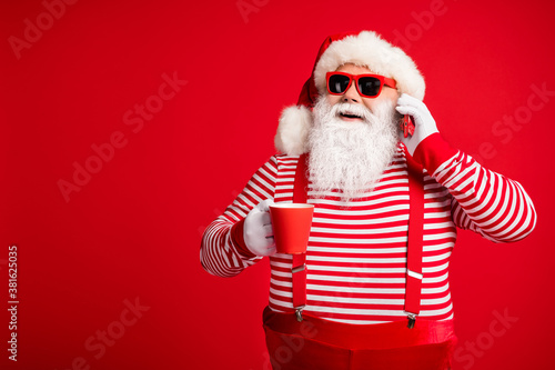 Portrait of his he nice handsome cheerful cheery bearded fat overweight Santa wear costume drinking cacao eggnog talking on phone isolated bright vivid shine vibrant red color background © deagreez