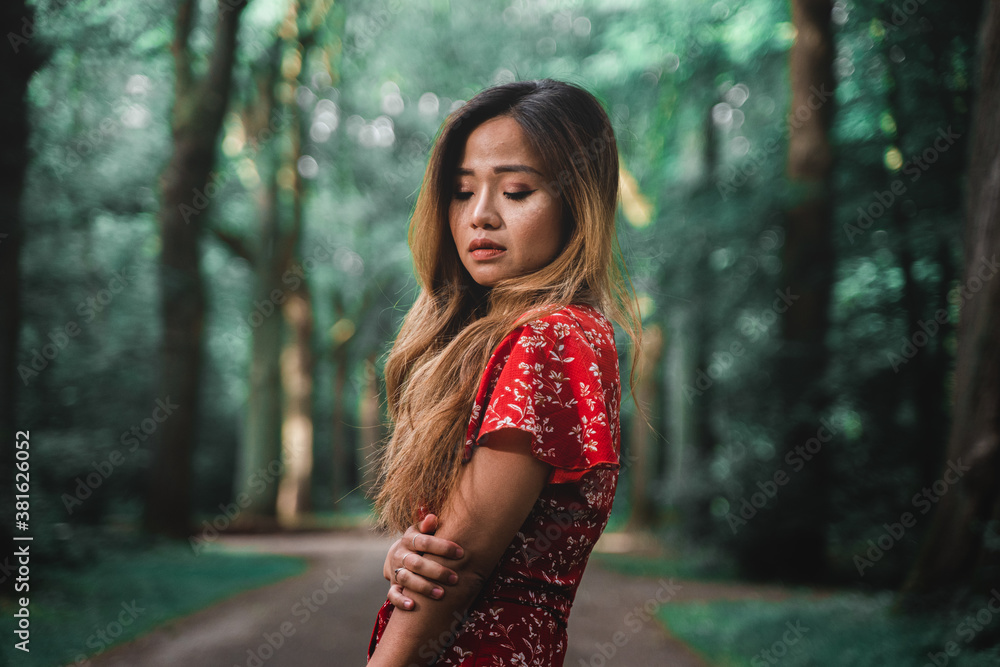 Beautiful Asian woman wearing red dress in a park Beautiful Asian woman wearing red dress in a park