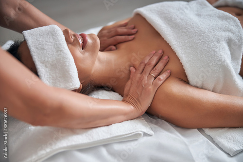 Masseur hands massaging female shoulders in spa salon © Svitlana