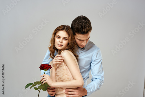 Cheerful young couple romance embrace relationship red rose lifestyle light background