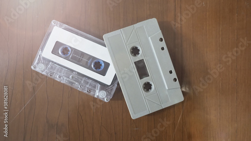 Close-up images of cassette tape on retro wood table. represent nostalgia mood or moment to 80s or 90s that most of audio music or songs recorded in compact and handy device technology.