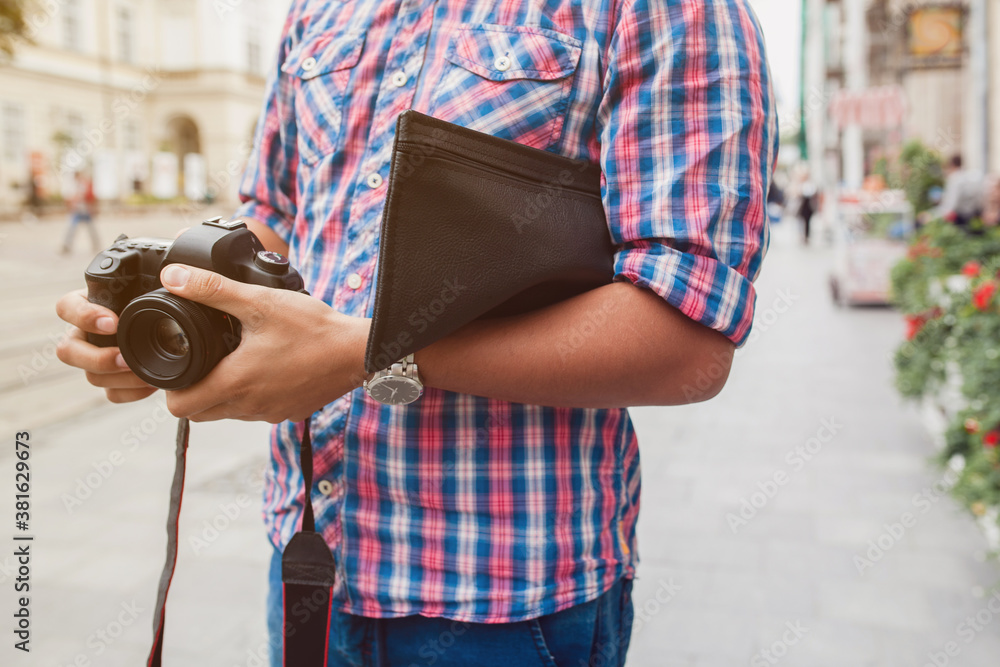 young handsome hipster man walking with photo camera on old city street, summer Europe vacation, travel, hands close up, sightseeing, taking pictures, details