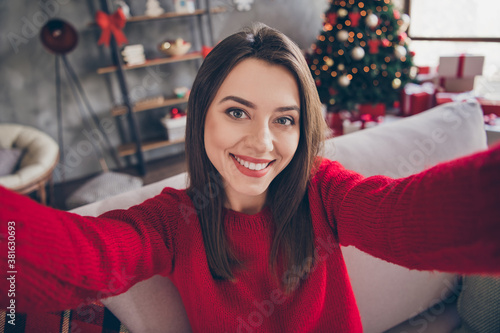 Photo of positive girl make selfie sit divan in house indoors with x-mas christmas advent decoration © deagreez