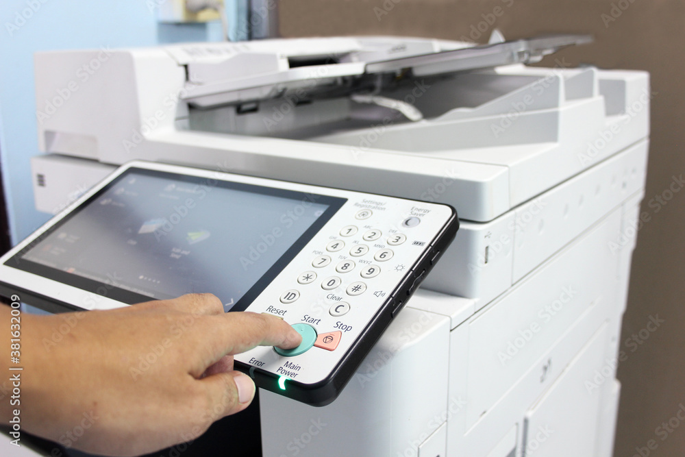 Bussiness man Hand press button on panel of printer, printer scanner laser office copy machine supplies start concept. Bussiness man Hand press button on panel of printer, printer scanner laser office copy machine supplies start concept.