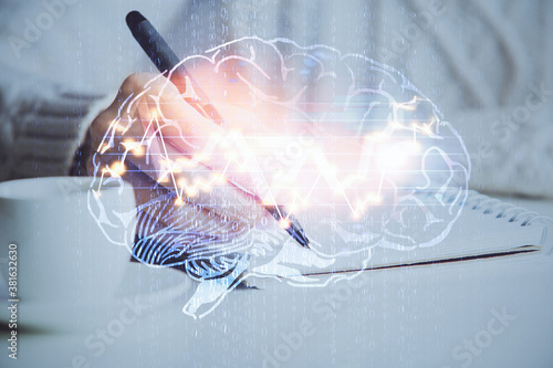 Multi exposure of writing hand on background with brain hologram. Concept of learning.