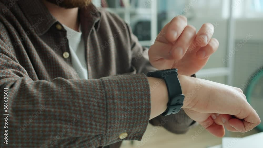 Close-up of guy's hand swiping digital watch screen checking messages with smart device, man is working in office. People and modern technology concept. Close-up of guy's hand swiping digital watch screen checking messages with smart device, man is working in office. People and modern technology concept.