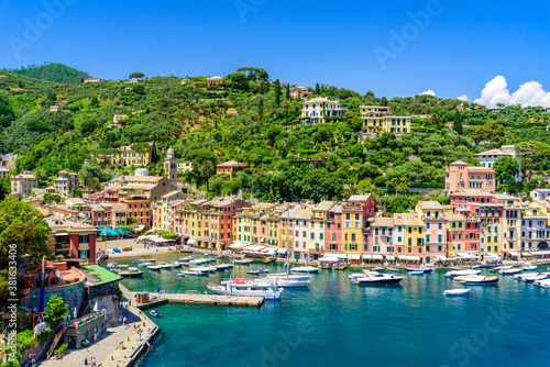Portofino, Italy - Harbor town with colorful houses and yacht in little bay. Liguria, Genoa province, Italy. Italian fishing village with beautiful sea coast landscape in summer season.