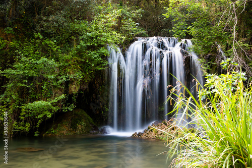 Beautiful waterfall in a pool in a magical environment. Silk effect water in long exposure. Gorg del Molí dels Murris, Planes d'Hostoles, Girona, Catalonia, Spain.
