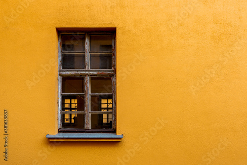 Old yellow house facade with wooden window
