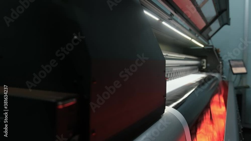 Drying the prints by heating. Printing machine that dries the print with its heated fans. Large format digital printing machine and moving print head.