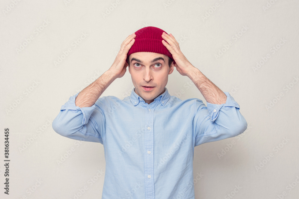 Attractive young guy in a red cap, white background, portrait Attractive young guy in a red cap, white background, portrait
