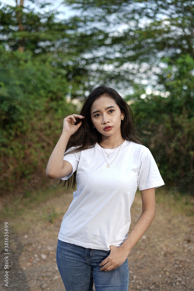 a stylish young woman wearing a white T-shirt against the backdrop of a forest view. black t-shirt models for mockups and templates. a stylish young woman wearing a white T-shirt against the backdrop of a forest view. black t-shirt models for mockups and templates.
