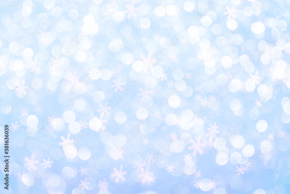 Abstract blue background with defocused lights and bokeh in the shape of snowflakes.Winter Christmas and New Year background.