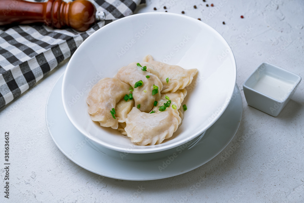 dumplings with potatoes on a plate on white concrete table dumplings with potatoes on a plate on white concrete table