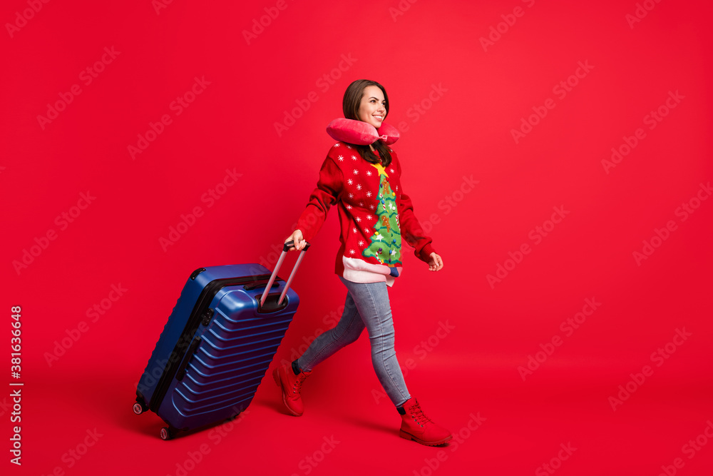 Obraz premium Full length body size view of her she nice attractive pretty cheerful girl walking carrying baggage traveling abroad destination flight isolated bright vivid shine vibrant red color background