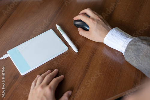 businessman sitting at the table, signs in a graphics tablet with a stylus. Close-up. Business. Electronic signature using a pen tablet