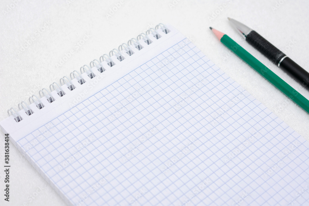 White notepad, pencil and ballpoint pen, top view, cropped image, white background, copy space White notepad, pencil and ballpoint pen, top view, cropped image, white background, copy space