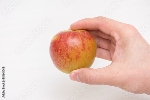 Person holding a red apple, man's hand, close-up