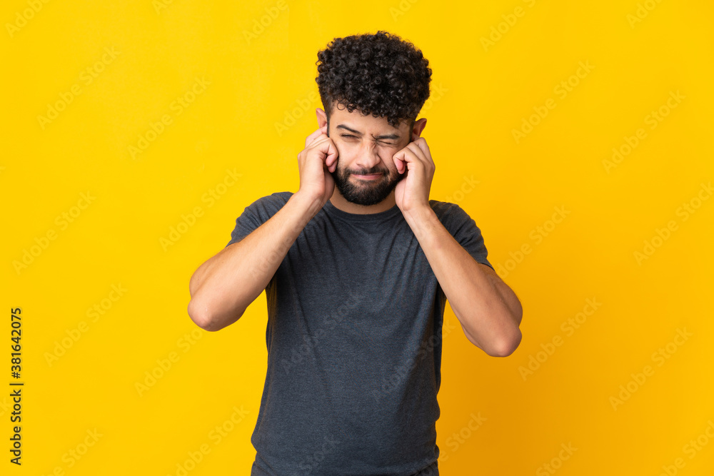Young Moroccan man isolated on yellow background frustrated and covering ears Young Moroccan man isolated on yellow background frustrated and covering ears