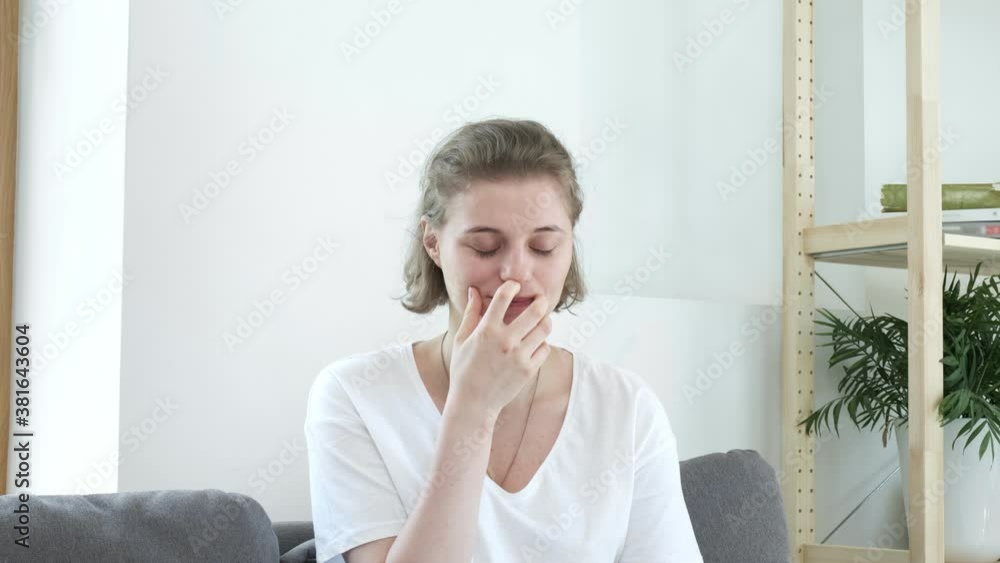 young caucasian smiling woman sighs at home. Portrait of female in white t-shirt. Short haired lady young caucasian smiling woman sighs at home. Portrait of female in white t-shirt. Short haired lady