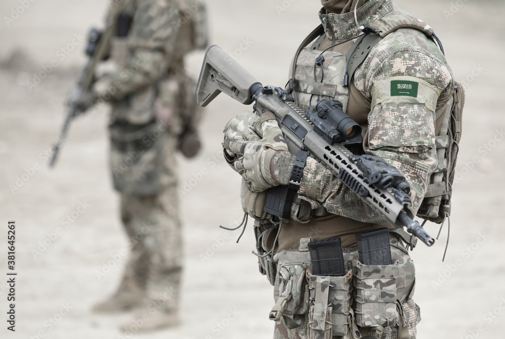 Soldiers with machine gun and flag of Saudi Arabia on military uniform