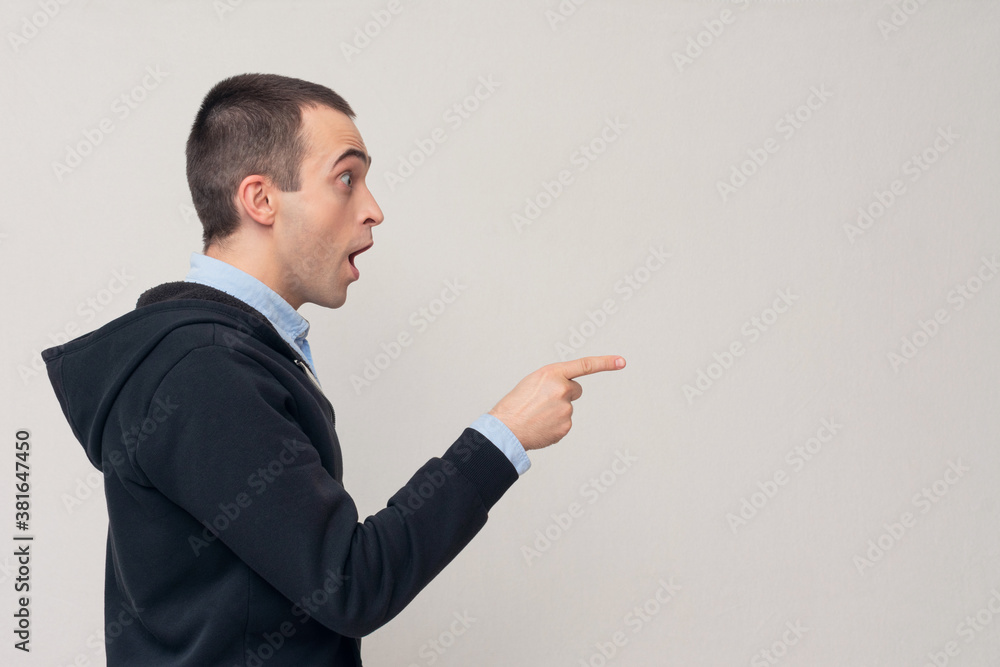 Surprised man with open mouth, pointing right, copy space, white background Surprised man with open mouth, pointing right, copy space, white background