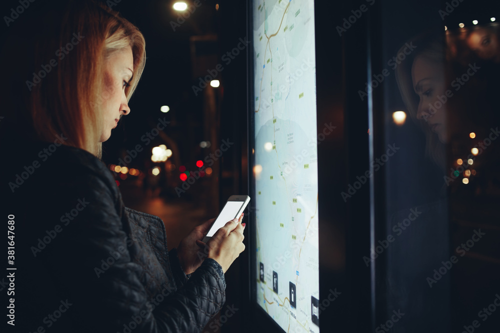 Woman using cellphone near kiosk on street Woman using cellphone near kiosk on street