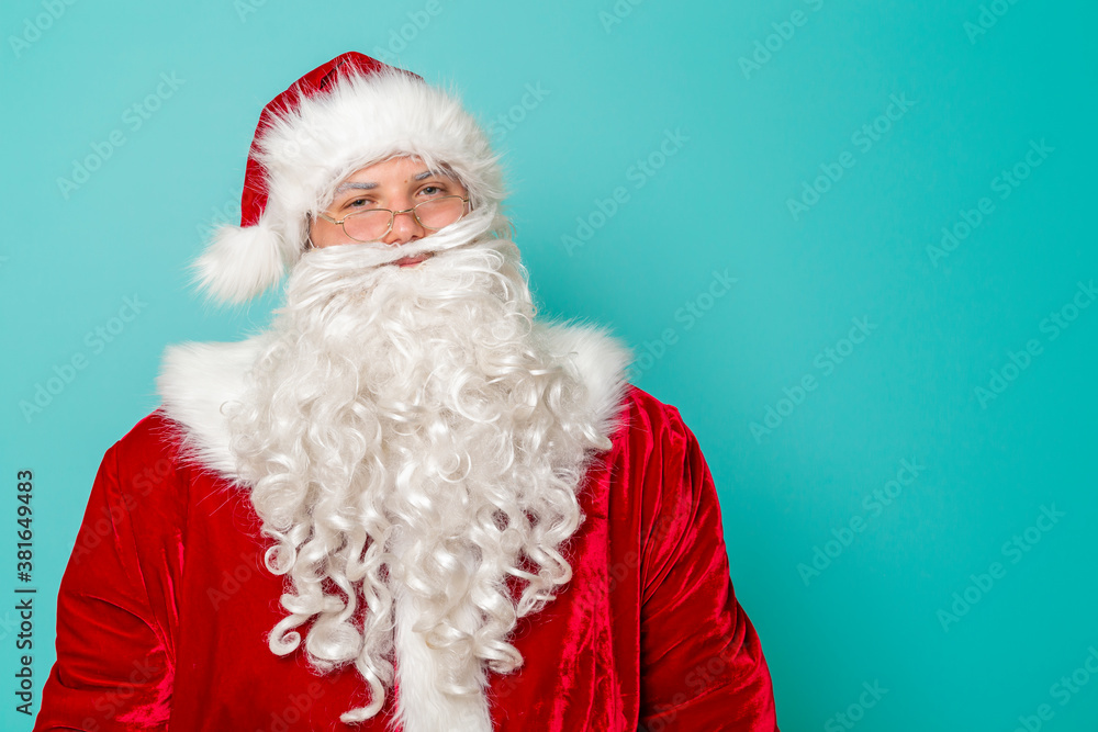 Santa Claus standing in front of mint colored background Santa Claus standing in front of mint colored background