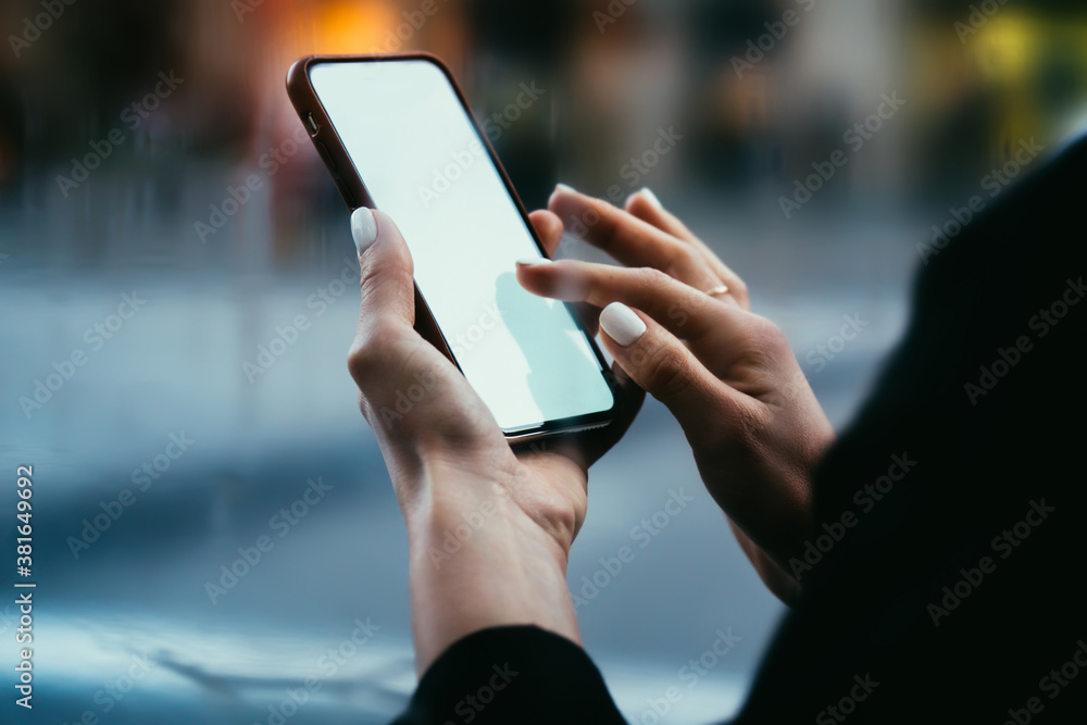 Crop faceless woman touching screen of smartphone for reading sms in street Crop faceless woman touching screen of smartphone for reading sms in street