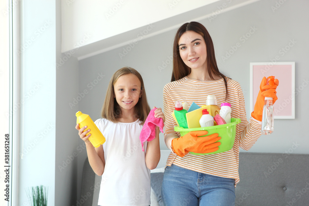 Mother and daughter in a good mood are cleaning the house with disinfectants and detergents Mother and daughter in a good mood are cleaning the house with disinfectants and detergents