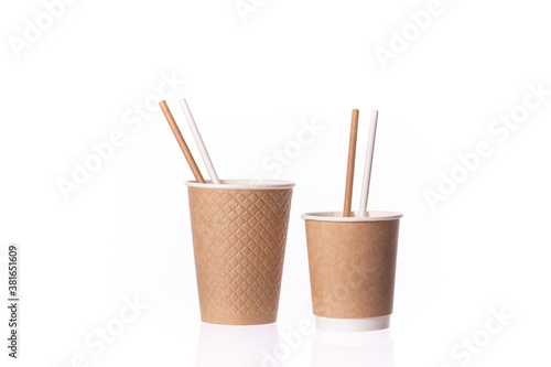 Two disposable brown paper cups small and medium sizes with straws isolated on white background. Coffee to go, takeaway hot drinks, cafe, eco-friendly tableware concept, mockup template. Copy space