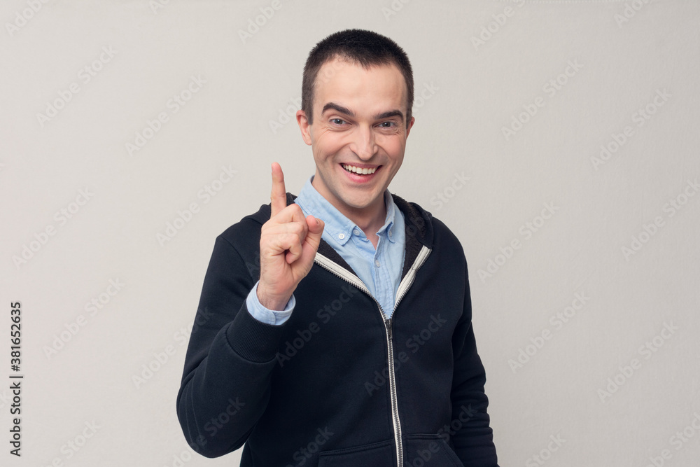Man raises fore finger as gets remembers to do something, remember error, white background, copy space Man raises fore finger as gets remembers to do something, remember error, white background, copy space