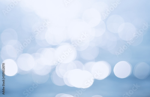 Delicate blue texture bokeh sea background. blurry blue bokeh glare on the water on a sunny day. rest and travel