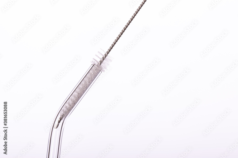Eco-Friendly Drinking Straw Set with Cleaning Brushes. Small cleaning brush inside curved transparent glass reusable straw for drinks isolated on white background. Zero waste concept Eco-Friendly Drinking Straw Set with Cleaning Brushes. Small cleaning brush inside curved transparent glass reusable straw for drinks isolated on white background. Zero waste concept