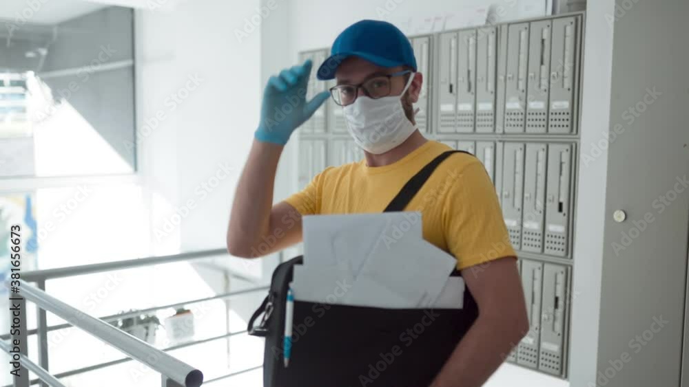 Mailman delivering mail with mail-bag and protective mask and gloves during virus pandemic. Mailman delivering mail with mail-bag and protective mask and gloves during virus pandemic.
